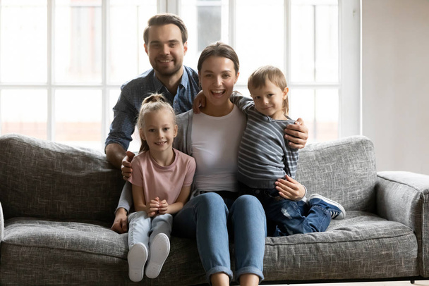 Portrait de famille heureuse avec des enfants se détendre sur le canapé
 - Photo, image