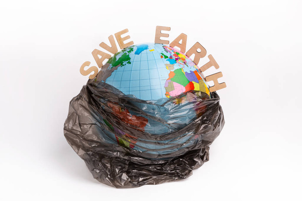 Save the Earth text and globe in plastic bag isolated on white - Photo, Image