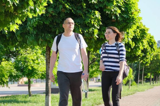 Mature couple walking and talking man and woman - 写真・画像