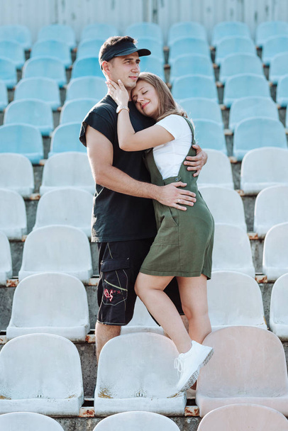 Młoda para przytulająca się na stadionie - Zdjęcie, obraz