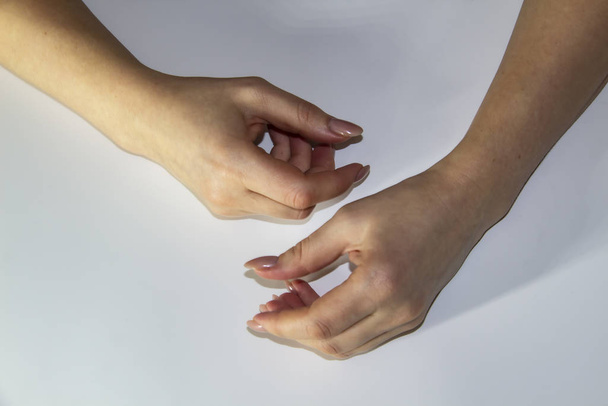Μια σύνθεση των χεριών των γυναικών που δείχνουν κίνηση φως φόντο. Τα γυναικεία χέρια δείχνουν κάτι. Έννοια με γυναικεία χέρια. - Φωτογραφία, εικόνα