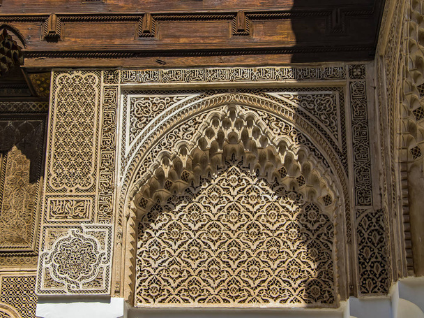 Detail of islamic building. It is an old architecture in the middle of the Moroccan city. There are white walls with wooden carved characters. There is summer time. - Photo, Image