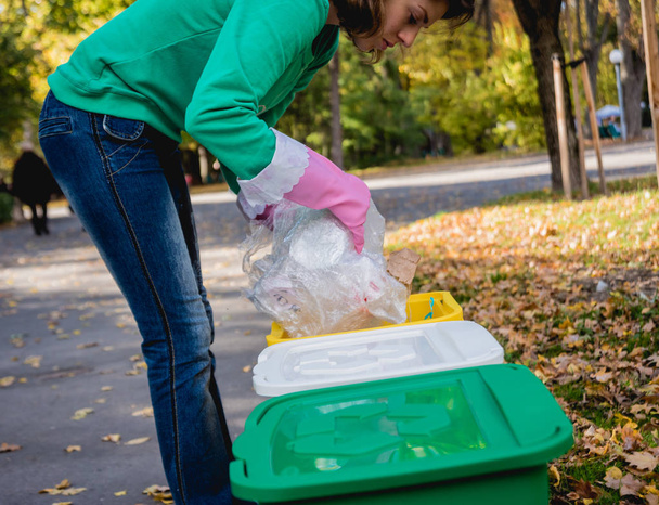 Volunteer girl sorts garbage in the street of the park. Concept of recycling. Zero waste concept. Nature - Fotografie, Obrázek