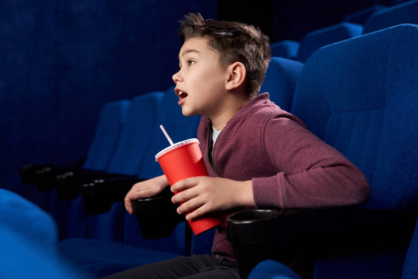Excited teen with watching action movie in cinema - Fotó, kép
