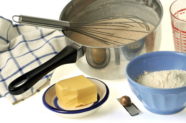 Bechamel sos zapiekanka z trzepaczką i składników zbliżenie na białym tle - Zdjęcie, obraz