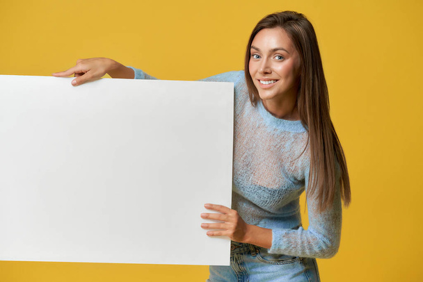 Smiling girl holding white poser - Zdjęcie, obraz