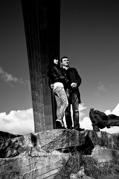 пара стоїть на скелі під аркою
 - Фото, зображення