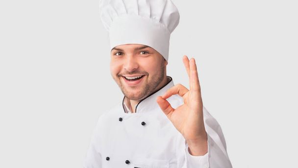 selbstbewusster Küchenmann gestikuliert okay zustimmend Rezept, weißer Hintergrund - Foto, Bild