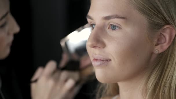 Closeup of female face while doing makeup in salon - Materiał filmowy, wideo