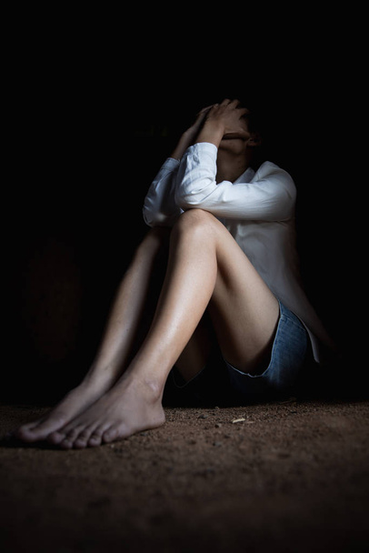Nők emberkereskedelme, egy nő a földön ülve, szexuális viv - Fotó, kép
