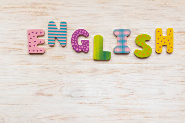 Ξύλινα γράμματα γραμμένα λέξη Αγγλικά σε ξύλινο φόντο - Φωτογραφία, εικόνα
