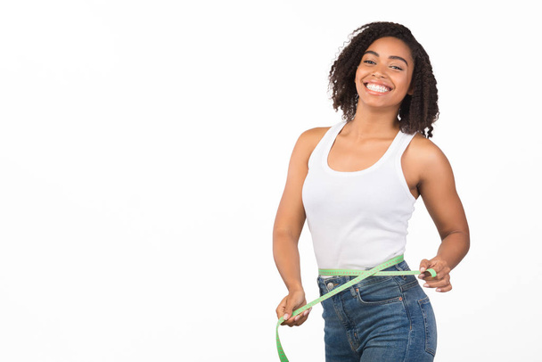 Portrait of young black girl measuring waist - Foto, Imagem