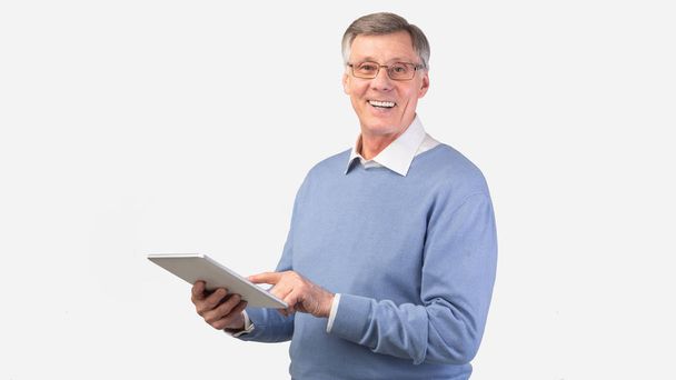 Uomo anziano sorridente che utilizza la tavoletta digitale in piedi, Studio Shot, Panorama
 - Foto, immagini