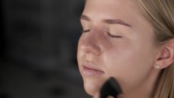 Young lady having her makeup done in beauty studio - Metraje, vídeo