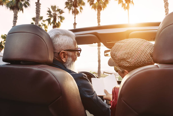 Szczęśliwa para seniorów bawiących się na nowym, kabrioletowym samochodzie - Dojrzałe osoby cieszące się razem czasem podczas wakacji na drodze - Starszy styl życia i koncepcja transportu podróżnych - Zdjęcie, obraz