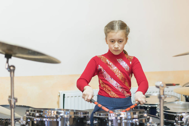 Teen girl playing the drums. Teen girl having fun playing drums. - Photo, Image