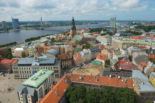 Riga, Letonia - 04 de agosto de 2009: Panorama de los edificios del casco antiguo y el puente sobre el río Daugava desde la iglesia de San Pedro en la ciudad de Riga, Letonia
. - Foto, imagen