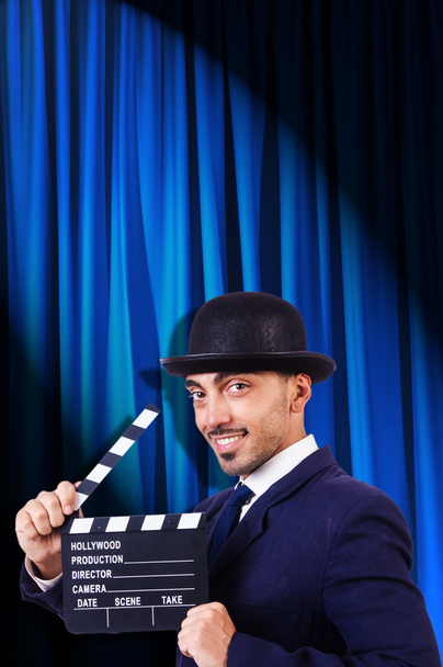 Man with movie clapper on curtain background - Photo, Image