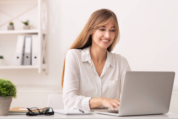 Επιτυχημένος επιχειρηματίας γυναίκα χρησιμοποιώντας φορητό υπολογιστή στο σύγχρονο γραφείο - Φωτογραφία, εικόνα