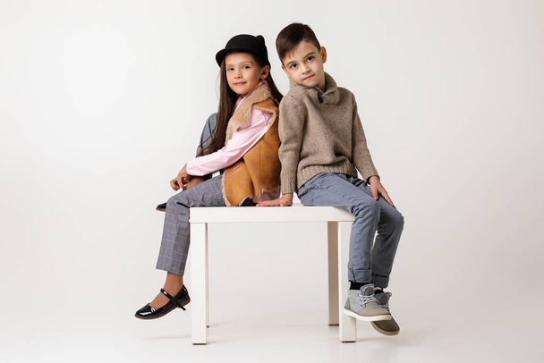 Cute stylish little couple child girl and boy sittting together . - Zdjęcie, obraz