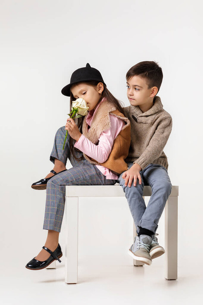 Cute stylish little couple child girl and boy sittting together . - Фото, изображение