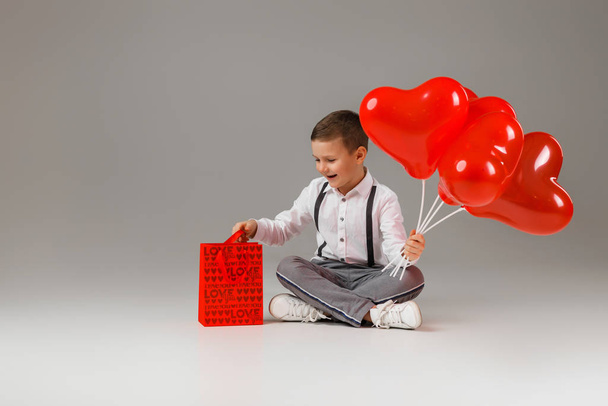 child boy holding red heart shaped balloon - Fotoğraf, Görsel
