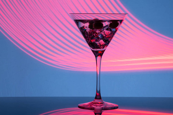 Glass of martini with ice shot in a long exposure in neon light - Foto, immagini