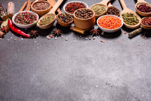 Набор специй и трав. Индийская кухня. Перец, соль, паприка, базилик и другие на темном фоне
 - Фото, изображение