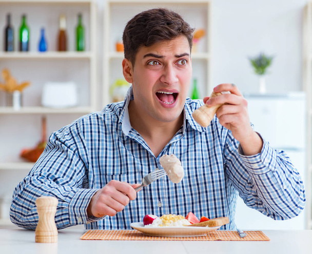 Mann isst zu Hause geschmackloses Essen zum Mittagessen - Foto, Bild