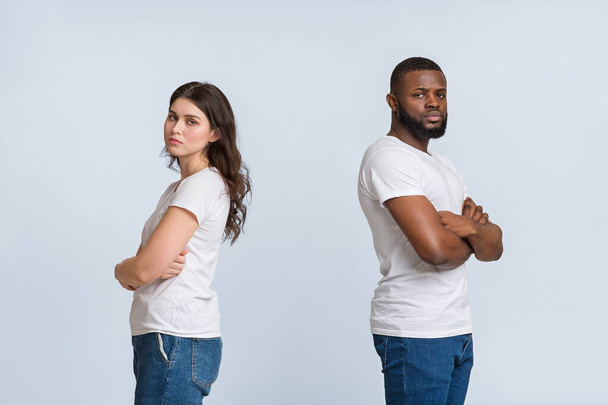 Upset interracial couple standing back to back with folded arms - Foto, Imagen
