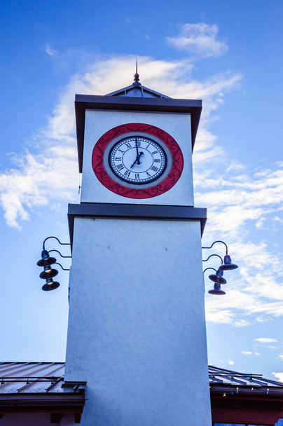 Valkoinen torni kellon kanssa ja pilvinen sininen taivas taustalla
 - Valokuva, kuva