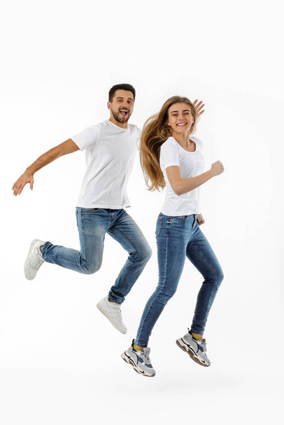 full length portrait of happy couple in casual outfit jumping - Fotografie, Obrázek