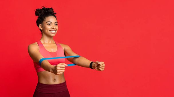 Boldog afro lány csinál nyújtás edzés ki rugalmas szalagok - Fotó, kép