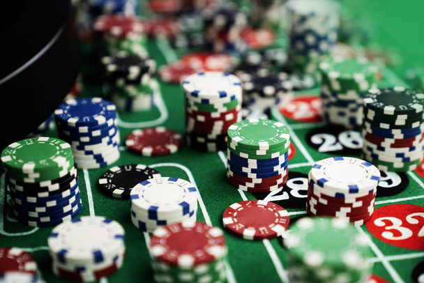 Stack of casino chips on green felt poker table - Photo, Image