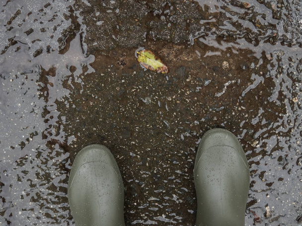 Wellington μπότες στο βρεγμένο πάτωμα με αντίγραφο χώρου - Φωτογραφία, εικόνα
