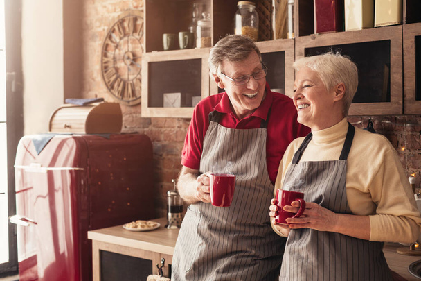 Getrouwd senior paar genieten van koffie in de keuken - Foto, afbeelding