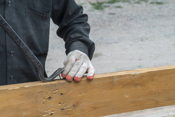 Рабочий плотник в грязной одежде работает на стройке
 - Фото, изображение
