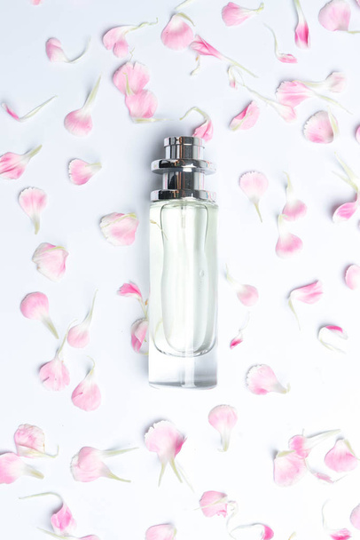 Perfume bottles and pink carnations on white background - Fotoğraf, Görsel