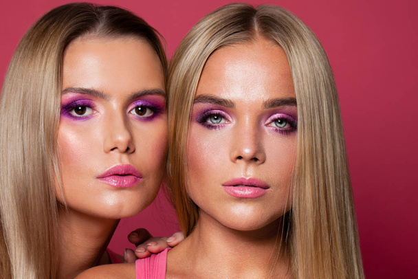 Belos modelos com maquiagem elegante no fundo rosa
 - Foto, Imagem