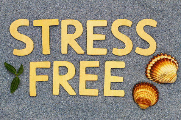 Без стресса написано деревянными буквами на голубом песке - Фото, изображение
