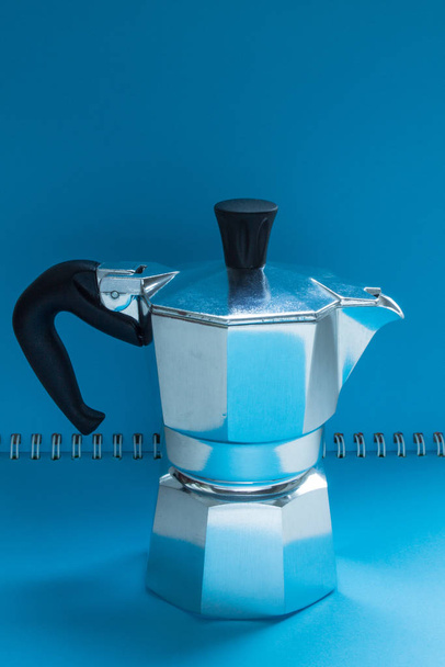 Metal coffee pot close up on a bright blue background - Fotó, kép