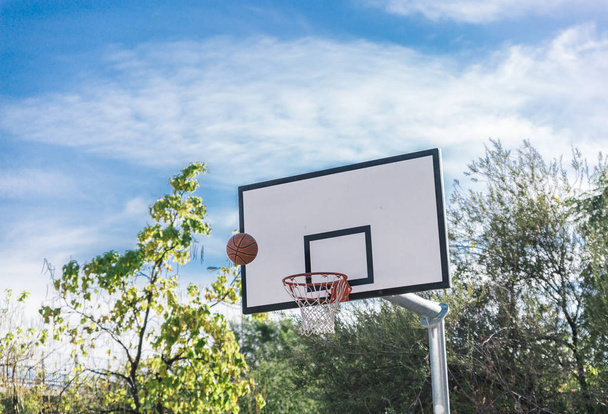 Panneau de basket d'un terrain de basket urbain et vue d'une balle dans les airs
 - Photo, image