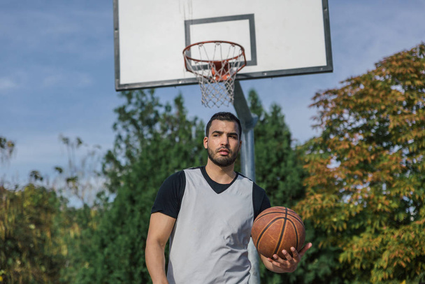 Joueur de basket urbain fort et grand dos au panier sur un terrain extérieur
 - Photo, image