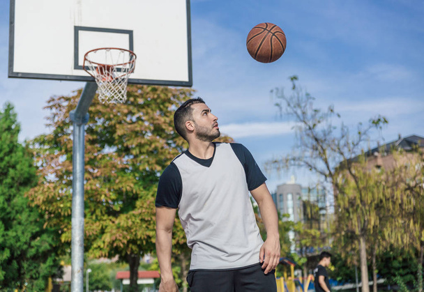 Giocatore di basket urbano lancia la palla in aria mentre sulla schiena al bordo e il cestino
 - Foto, immagini