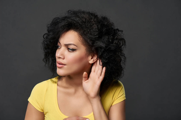 Serious woman listening gossip with palm shielding ear - Photo, Image