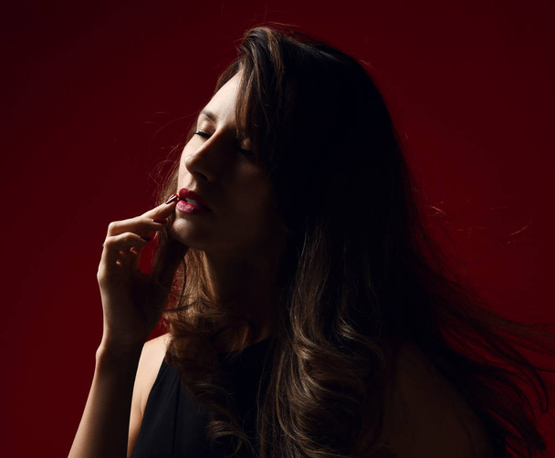 Beautiful woman fashion art studio portrait with windy hair and dark light modern earring posing - Foto, imagen