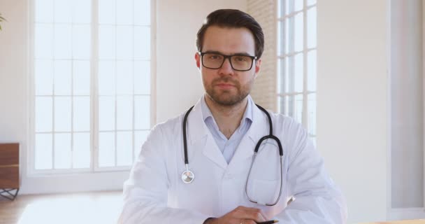 Confident professional male doctor consulting patient online doing video chat - Video, Çekim
