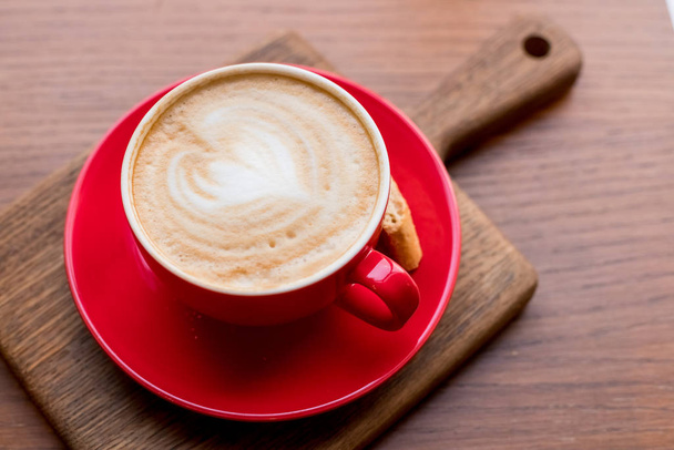Kahvitauko. Punainen kuppi cappuccinoa kauniilla lattella vanhalla puupohjalla. Latte art coffee.aroma kahvia punainen keraaminen kuppi. Kopioi space.wood pöytä kahvilassa, ravintola
 - Valokuva, kuva