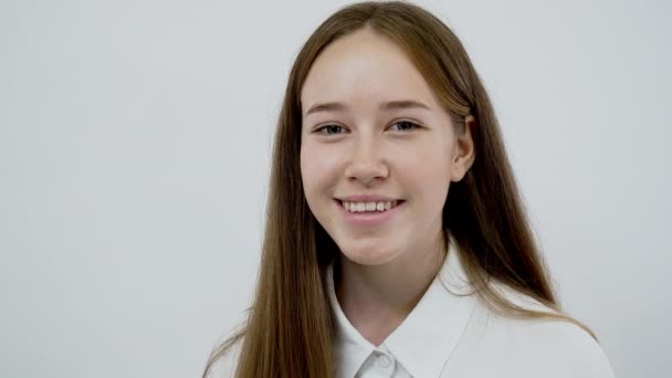 Portret van lachende blanke jonge meisje close-up geïsoleerd op witte achtergrond - Video