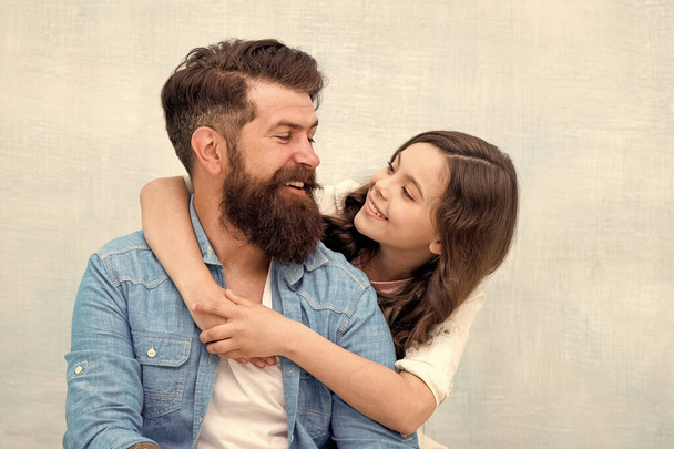 I loved her first. Bearded man and small girl child sharing love and laugh. Little daughter hugging father with love and care on grey background. Family love - Zdjęcie, obraz